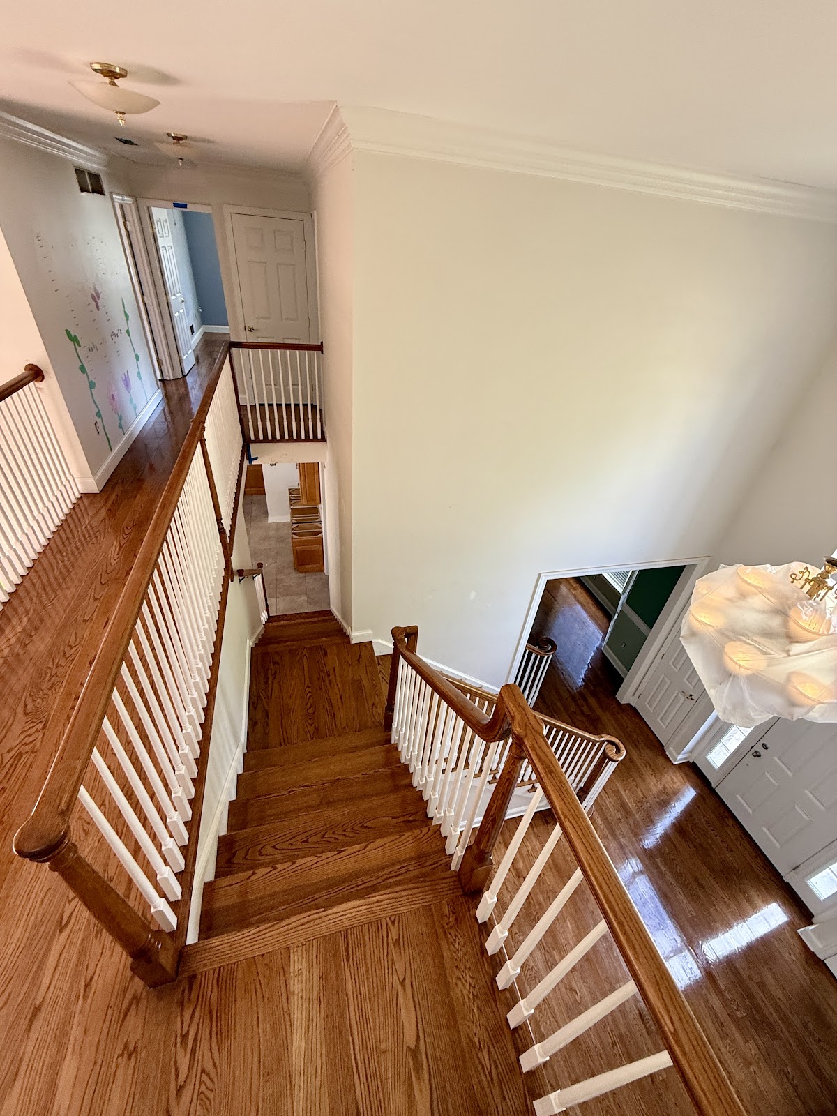 A finished staircase and hardwood floor landing with a glossy refinished sheen